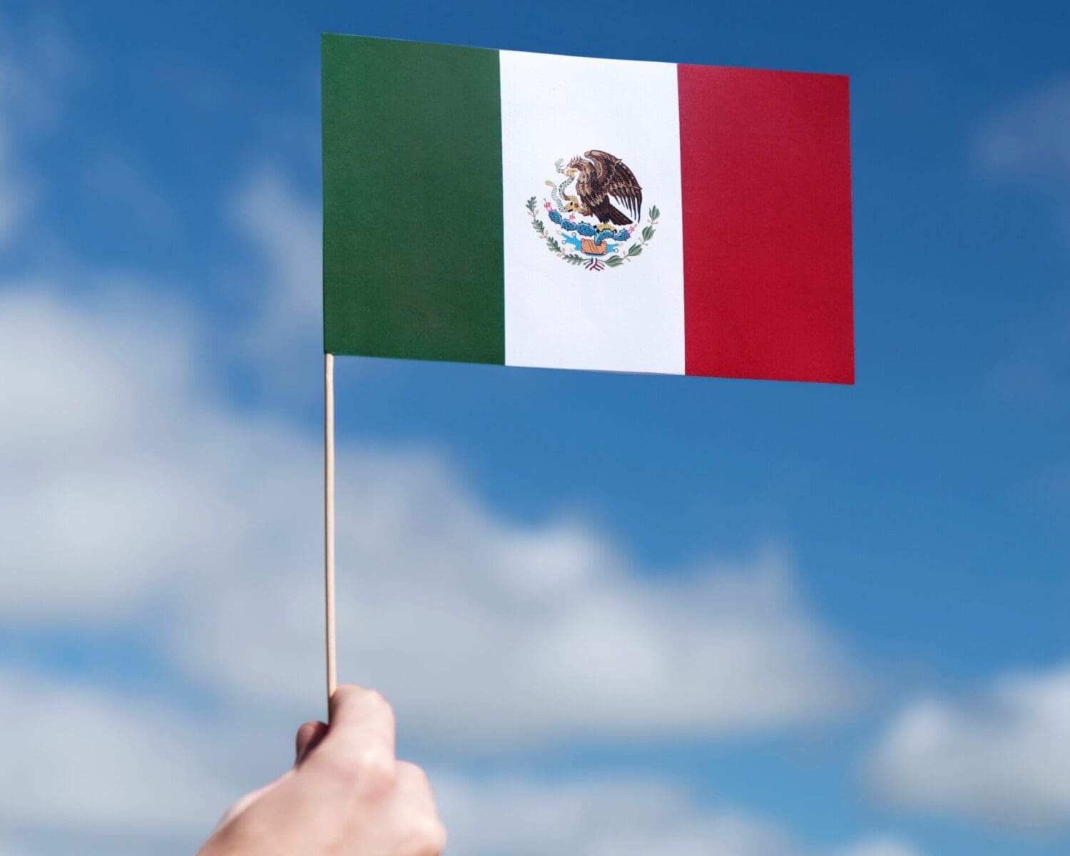 mao-segurando-a-bandeira-mexicana-ao-ar-livre méxico